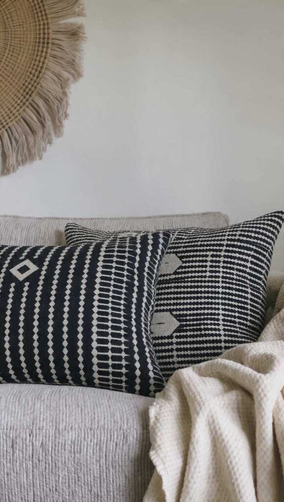 cuscini e arazzo in mudcloth bogolan bianco e nero in stile afrobohemien su divano in lino naturale