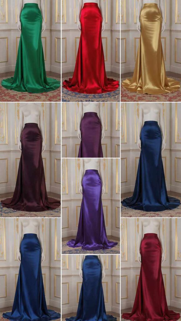 Immagine verticale 9:16 per Pinterest senza testo. Tre gonne lunghe eleganti in seta e satin con drappeggio fluido e lucentezza raffinata, nei colori nero, blu notte e bordeaux e tonalità gioiello vibranti come smeraldo e rubino. Ambientazione da cerimonia formale, illuminazione soft da studio, stile fotografia moda di alta gamma che esprime eleganza e raffinatezza.
