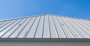 Inquadratura esterna di un tetto moderno in lamiera su casa indipendente, con cielo azzurro e sole pieno