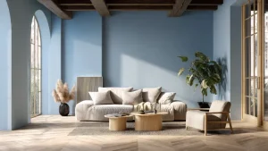 Salotto moderno con pareti celeste polvere, divano beige chiaro, tavolini in legno naturale, pavimento a spina di pesce chiaro, travi in legno a soffitto e finestre ad arco. Atmosfera luminosa, elegante e stile scandi-italiano.