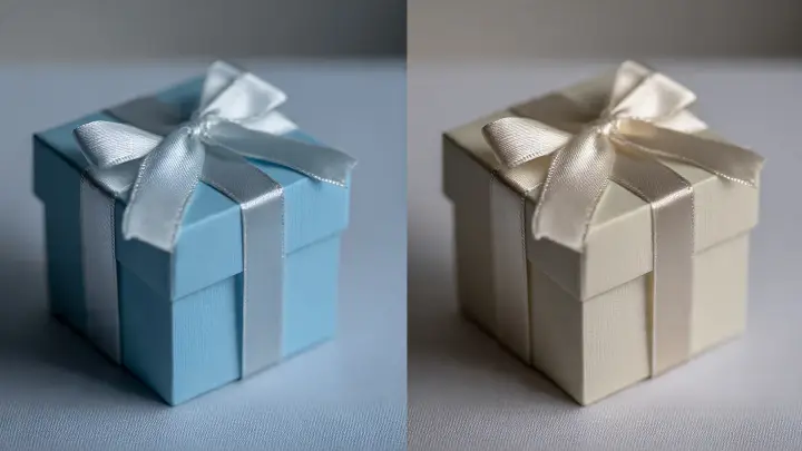 Due piccole scatoline bomboniera quadrate, una azzurra con nastro argento e una avorio con nastro panna, su sfondo chiaro