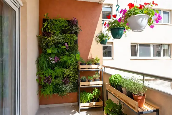 Giardino verticale con vasi sospesi su balcone Balcone piccolo con giardino verticale sulla parete, vasi sospesi con fiori e scaffale porta piante