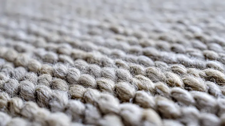 Dettaglio trama moquette bouclé beige - fibra intrecciata moderna Primo piano texture moquette beige bouclé a trama intrecciata, fibra morbida e resistente al calpestio