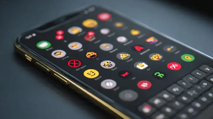 Primo piano di iPhone con Emoji Kitchen in dark mode su Gboard con sticker emoji