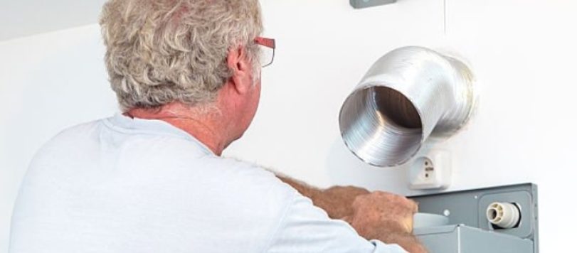 Horizontal composition shot of fitter technician men manual worker, installing integrated range hood, extractor fan, in a new kitchen custom made